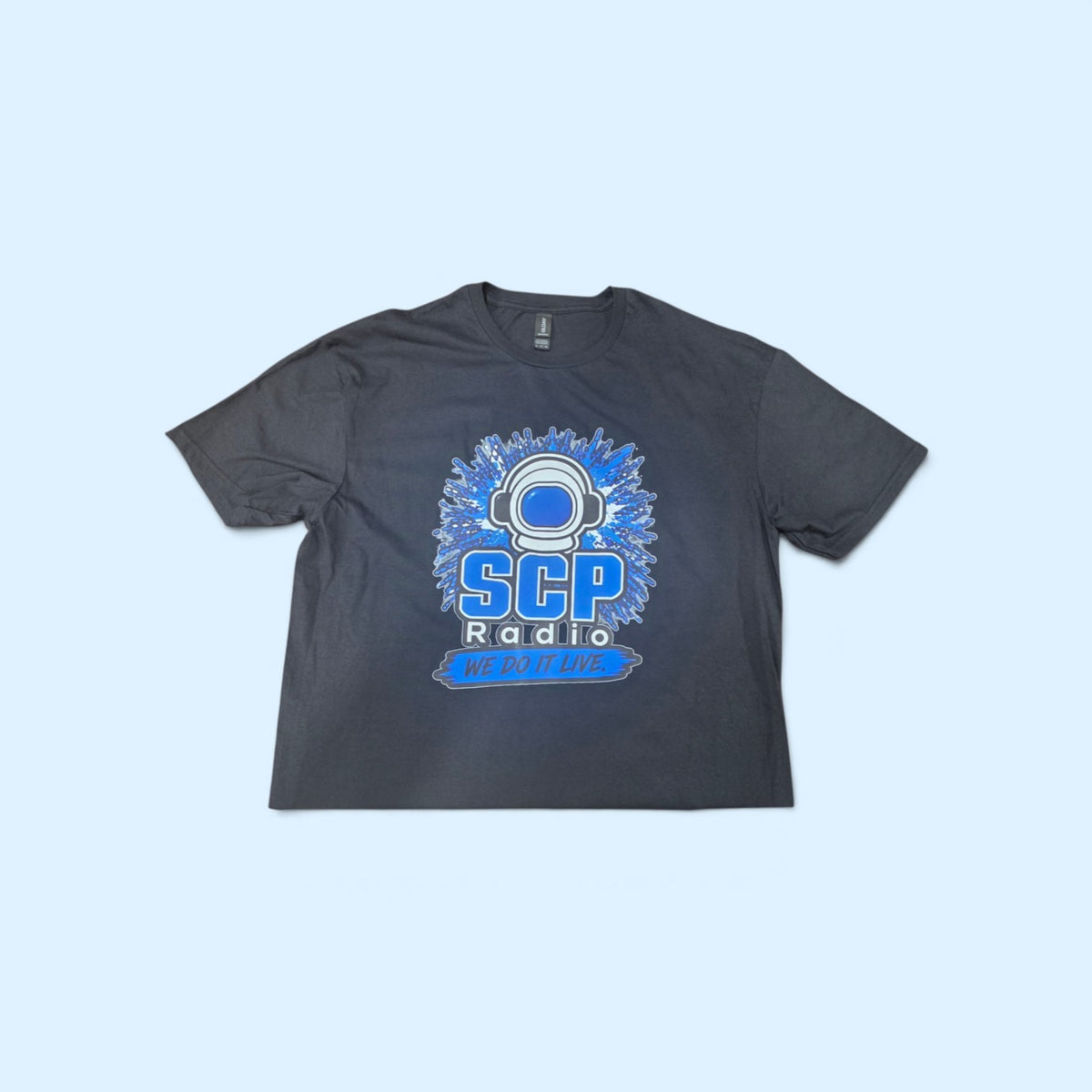 SCP Apparel black cotton crewneck t-shirt featuring a blue SCP Radio astronaut helmet graphic and We Do It Live text.