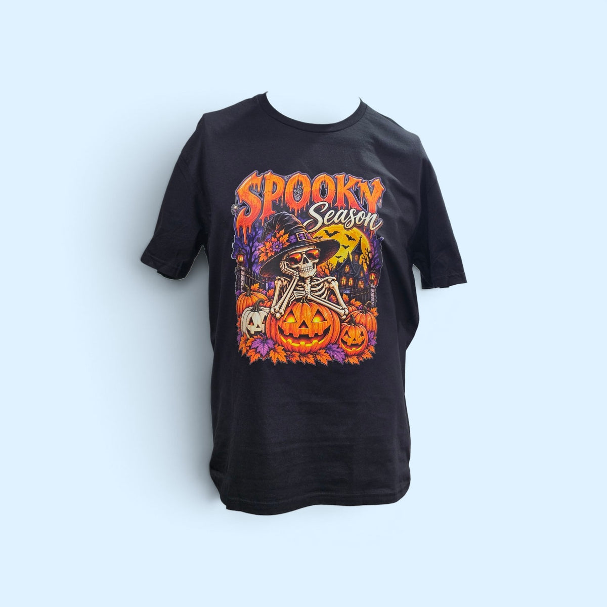 SCP Apparel black crewneck t-shirt featuring a vibrant skeleton wearing a witch hat and pumpkins graphic print.