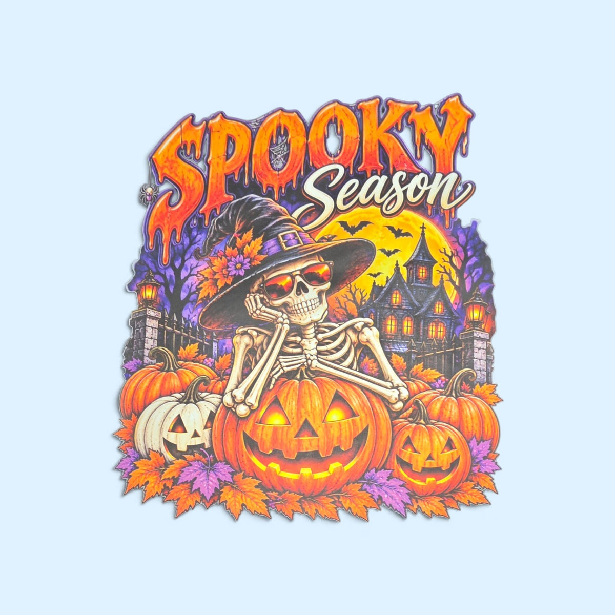 SCP Apparel Spooky Season graphic featuring a skeleton in a witch hat and sunglasses with pumpkins and a haunted house