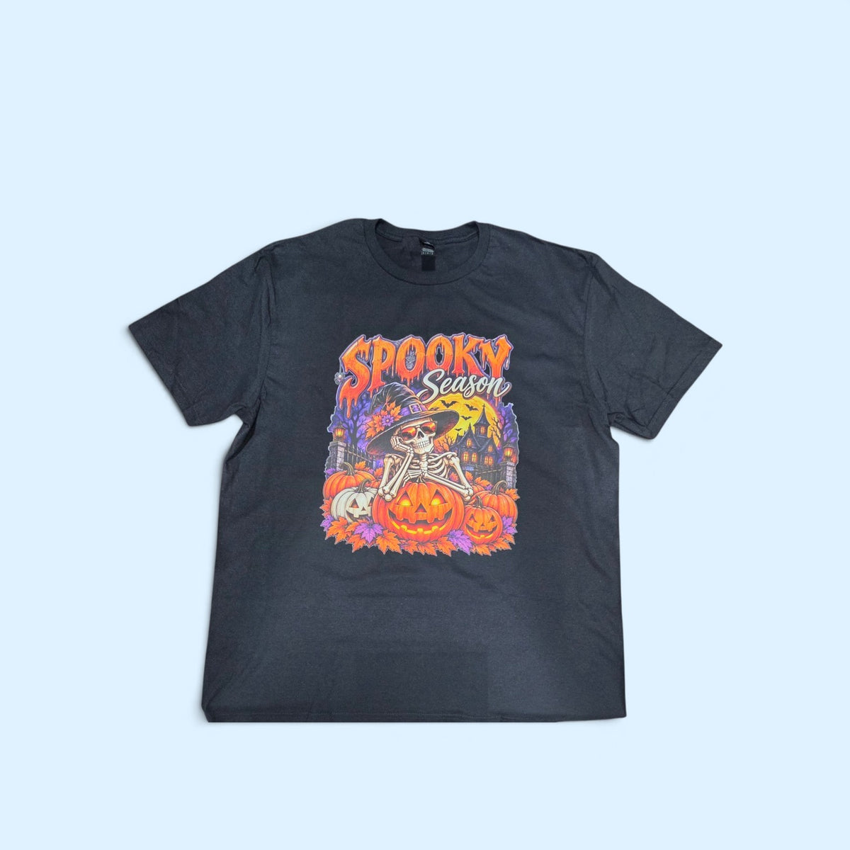 SCP Apparel black crewneck t-shirt featuring a colorful skeleton in a witch hat with pumpkins and haunted mansion